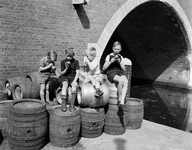 808309 Afbeelding van vier jongetjes met een flesje Joy limonade op een stapel vaten op de werf langs de Oudegracht te ...